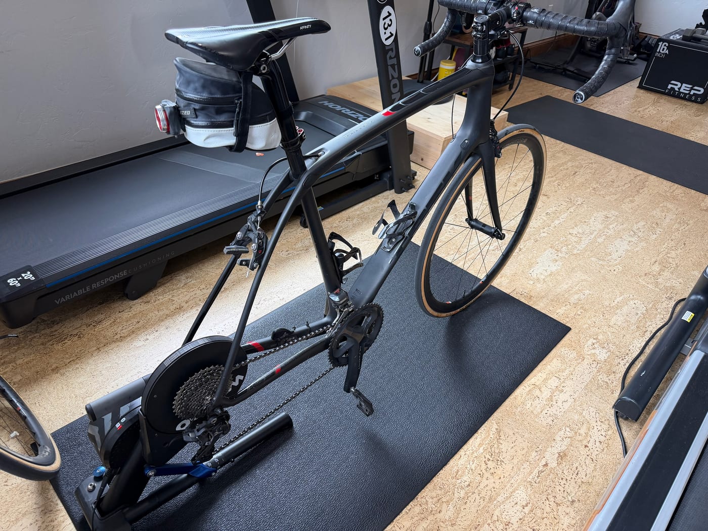 A road bike on a smart indoor trainer in a home workout space